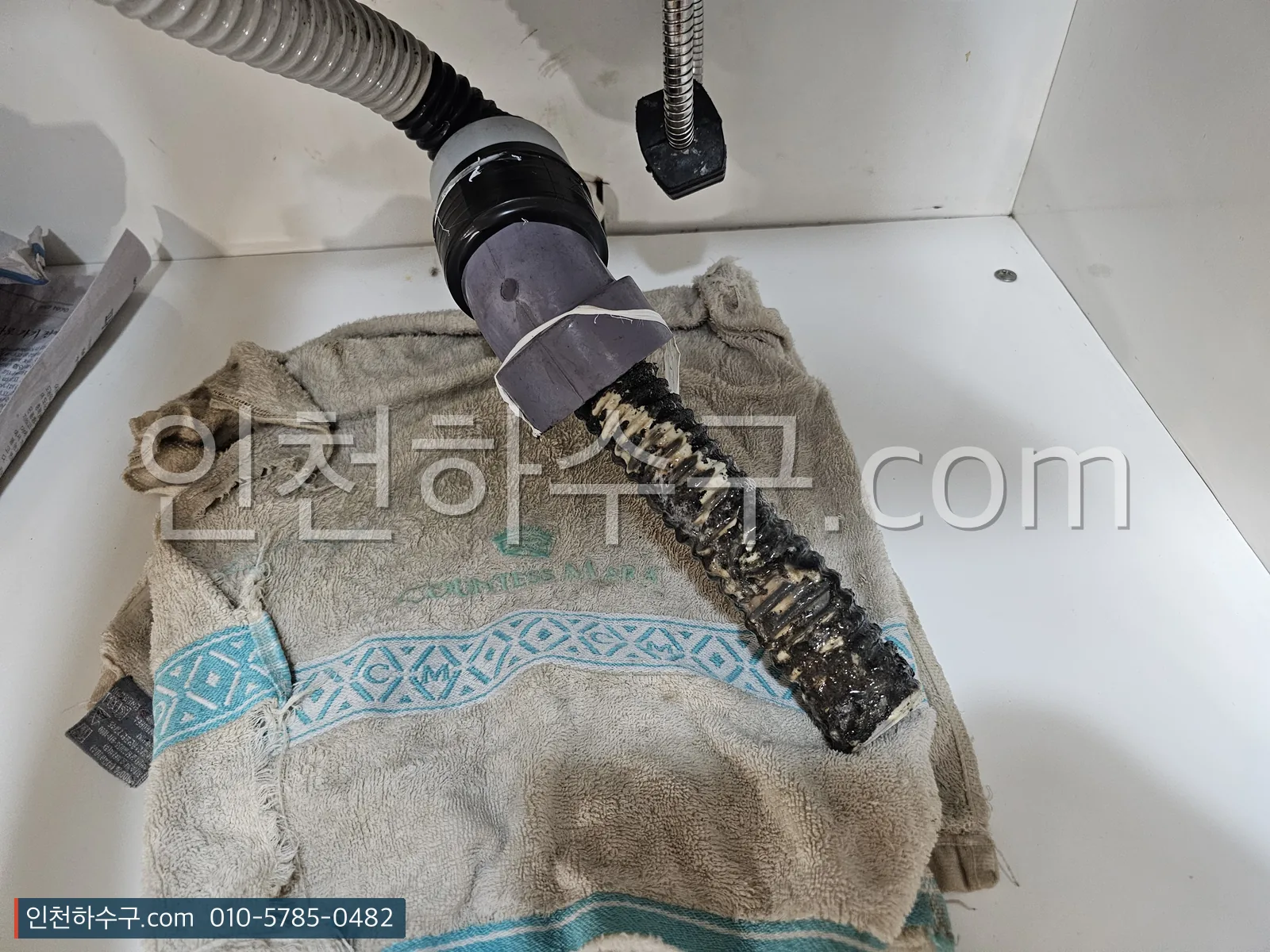 빼낸 드레인 호스 말단에 붙어 있던 이물