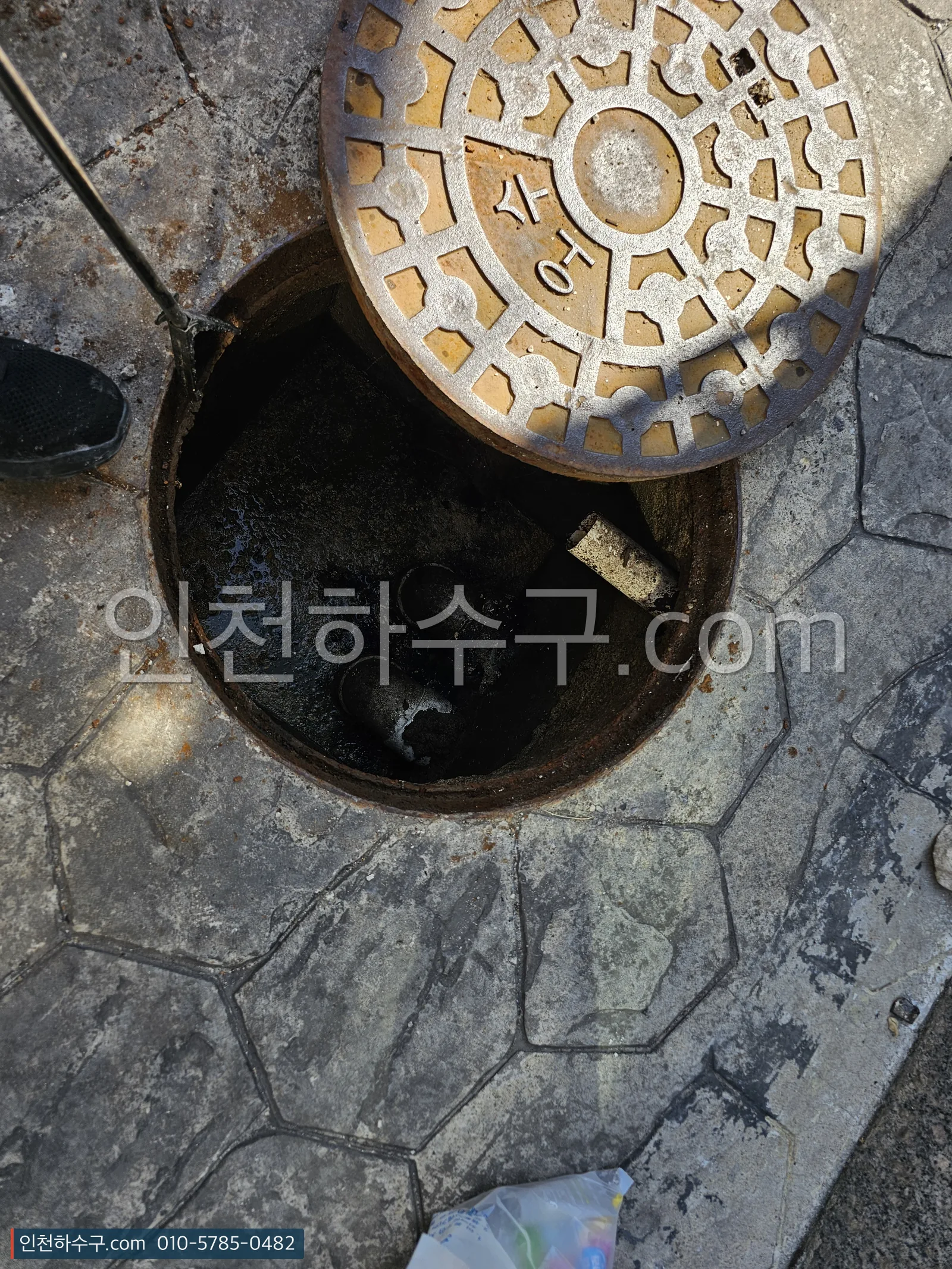 저지대 골목 오수 맨홀을 열어 배수 상태를 확인하는 장면