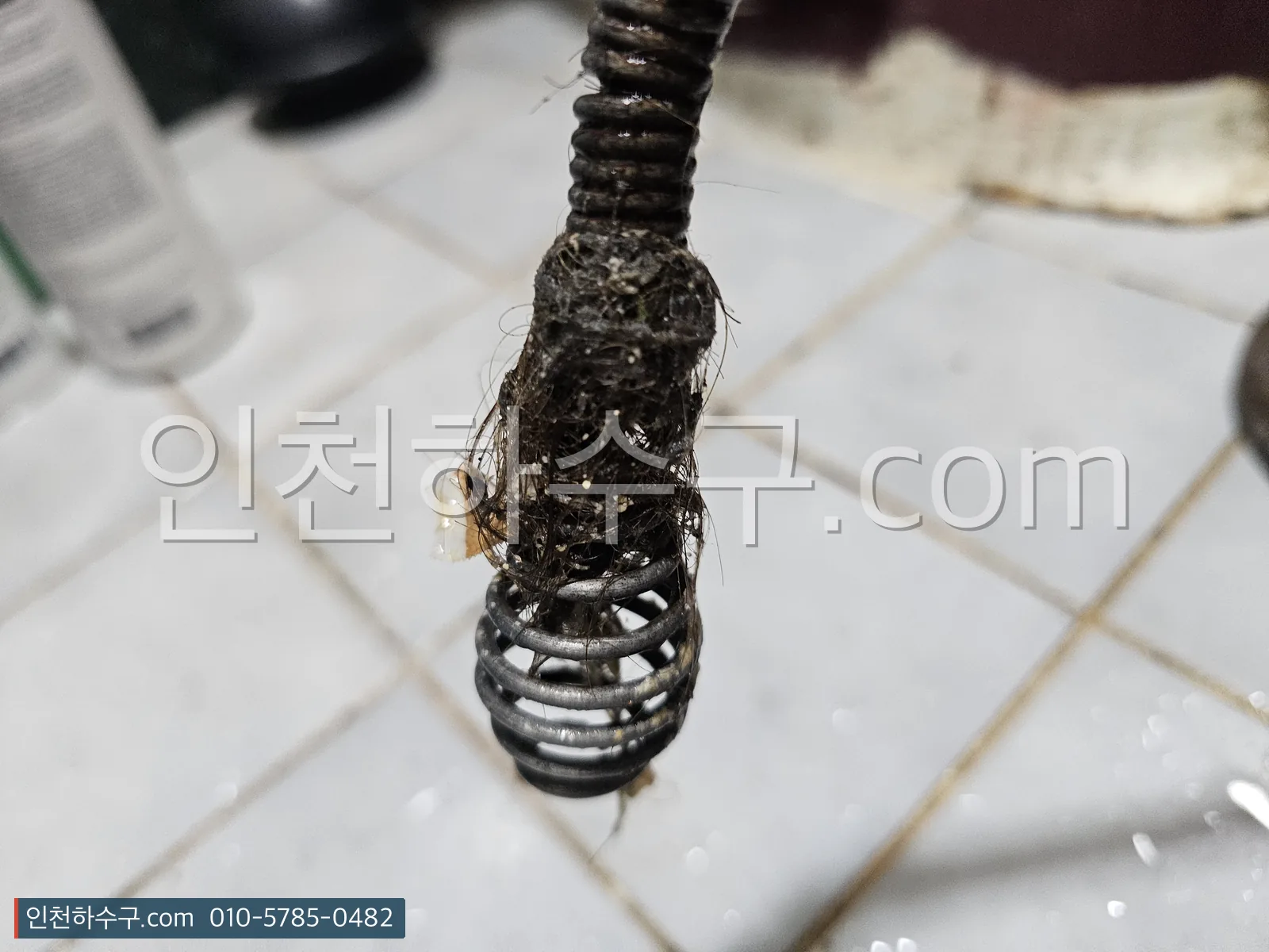 세면대 배수관에서 스프링으로 꺼낸 머리카락과 비누때가 엉킨 덩어리