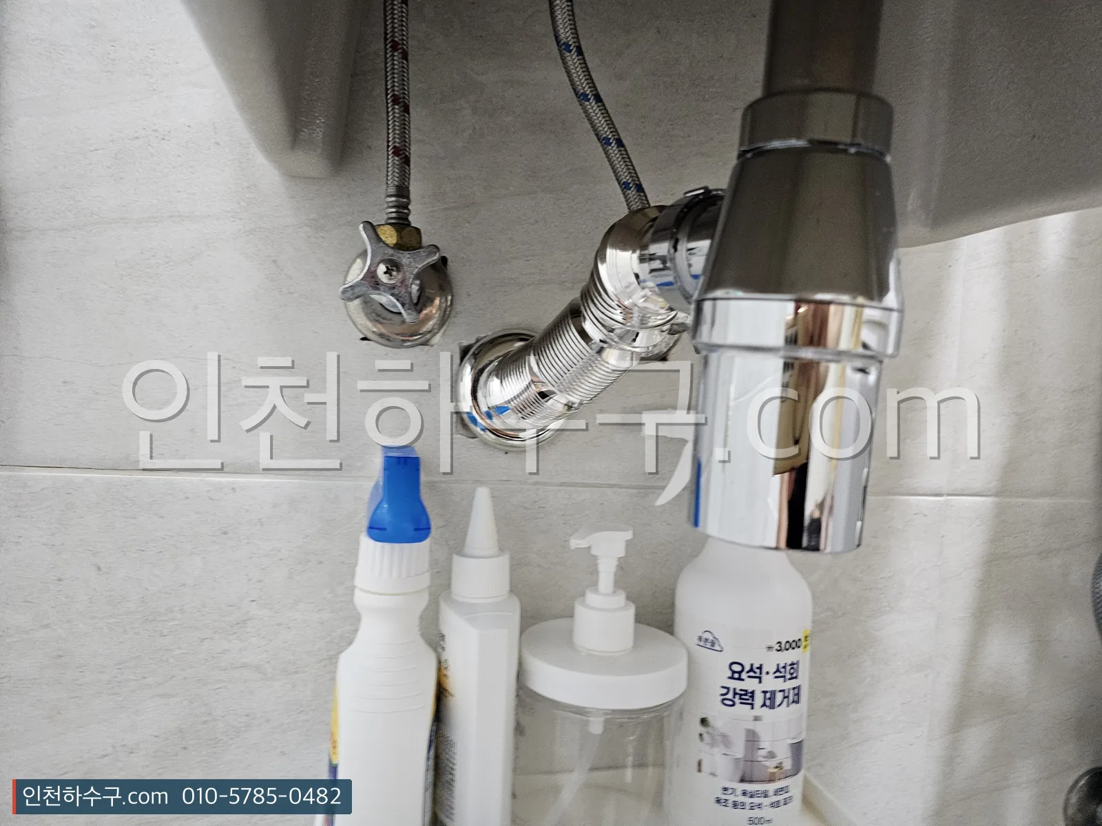 세면대 아래 P트랩과 앵글밸브 상태를 확인하는 모습
