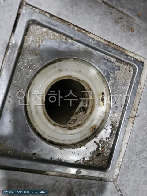 마른 바닥 배수구에서 유가(트랩)를 들어낸 뒤 배관이 드러난 모습