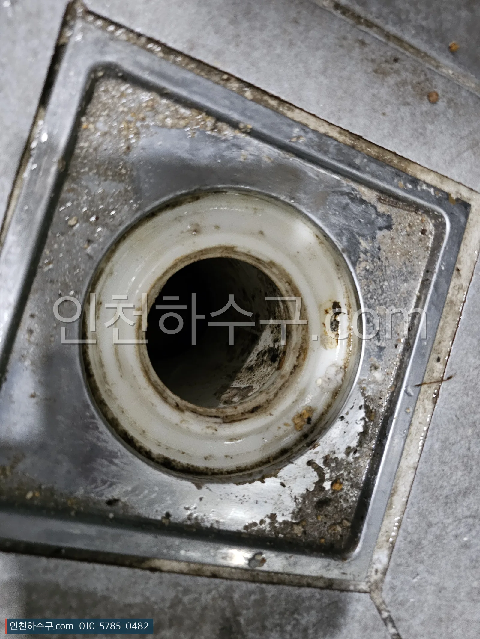 마른 바닥 배수구에서 유가(트랩)를 들어낸 뒤 배관이 드러난 모습
