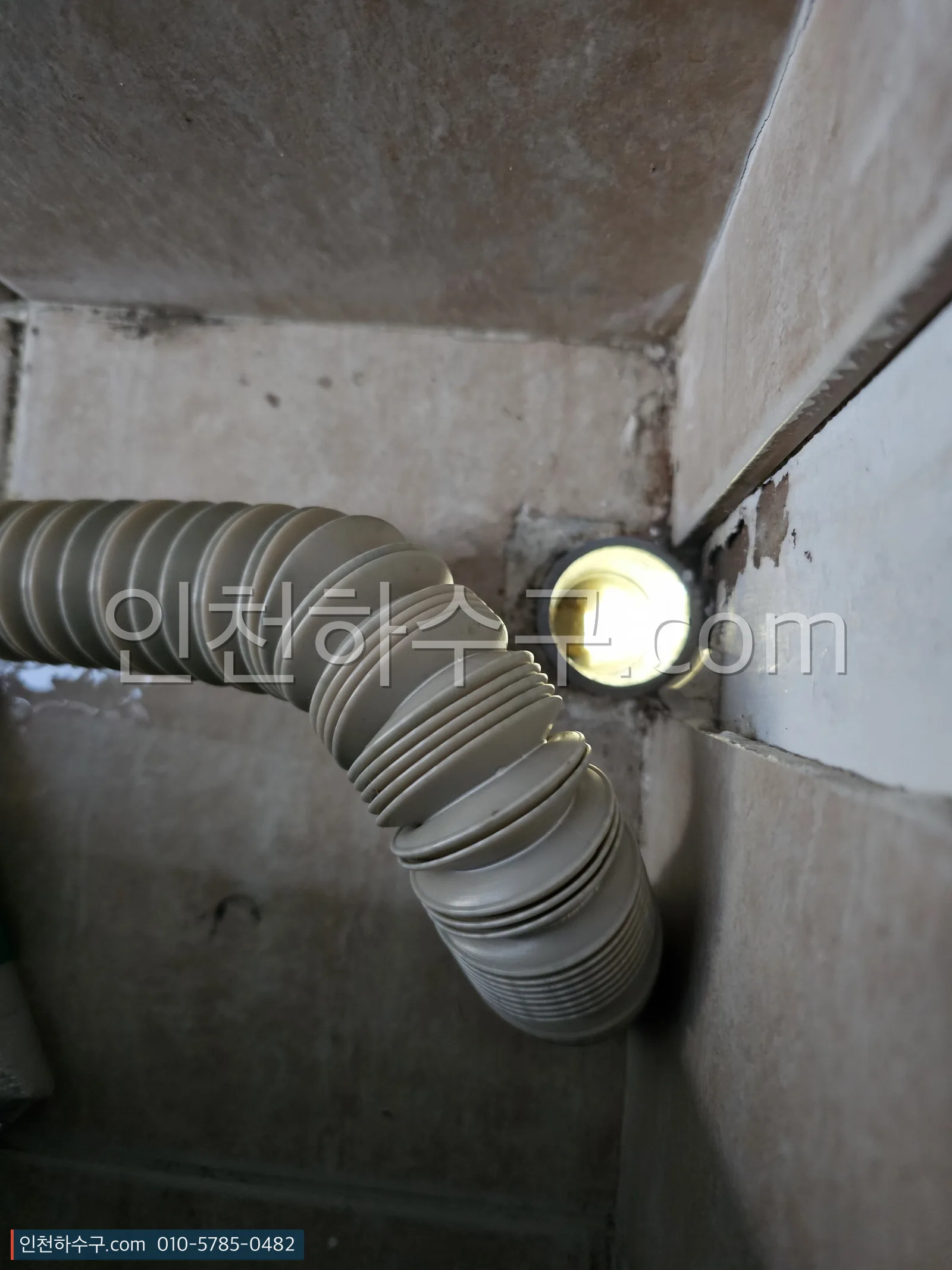 세면대 아래 주름 배수관이 벽 배관과 만나는 이음부 상태