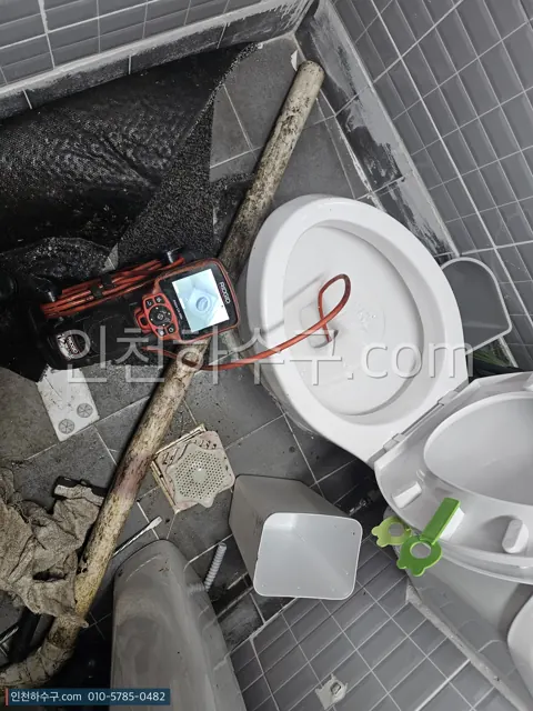변기를 탈거한 뒤 트랩 안을 내시경으로 확인하는 모습