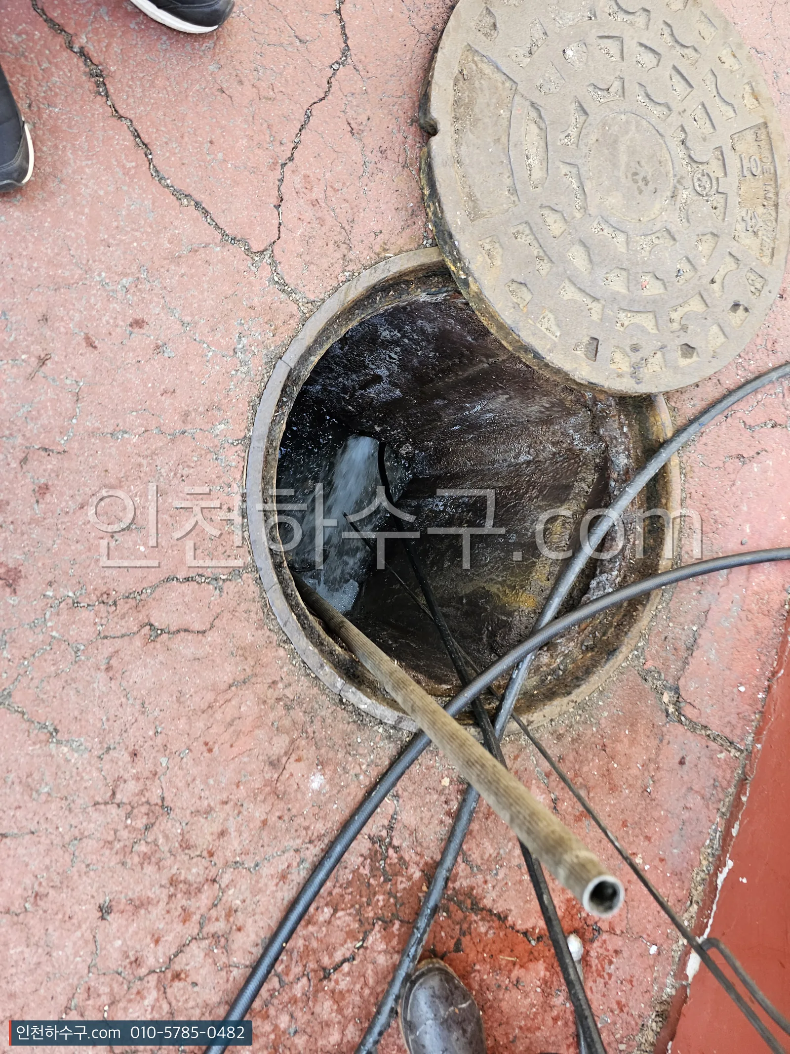 골목 오수 맨홀을 열어 본관 수위와 흐름을 확인하는 모습